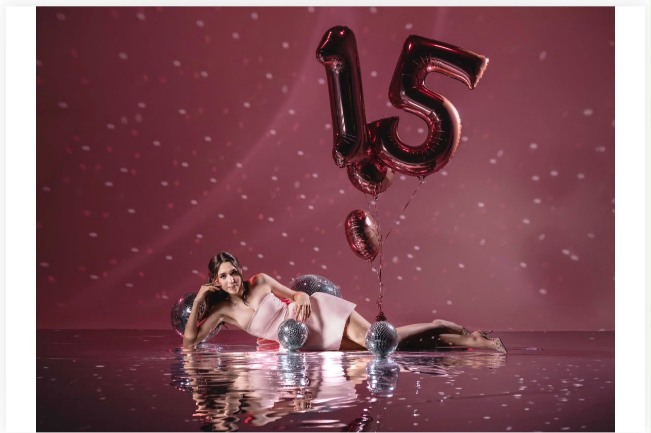 Natalia Aislinn con globos del número quince y esferas disco sobre fondo rosa